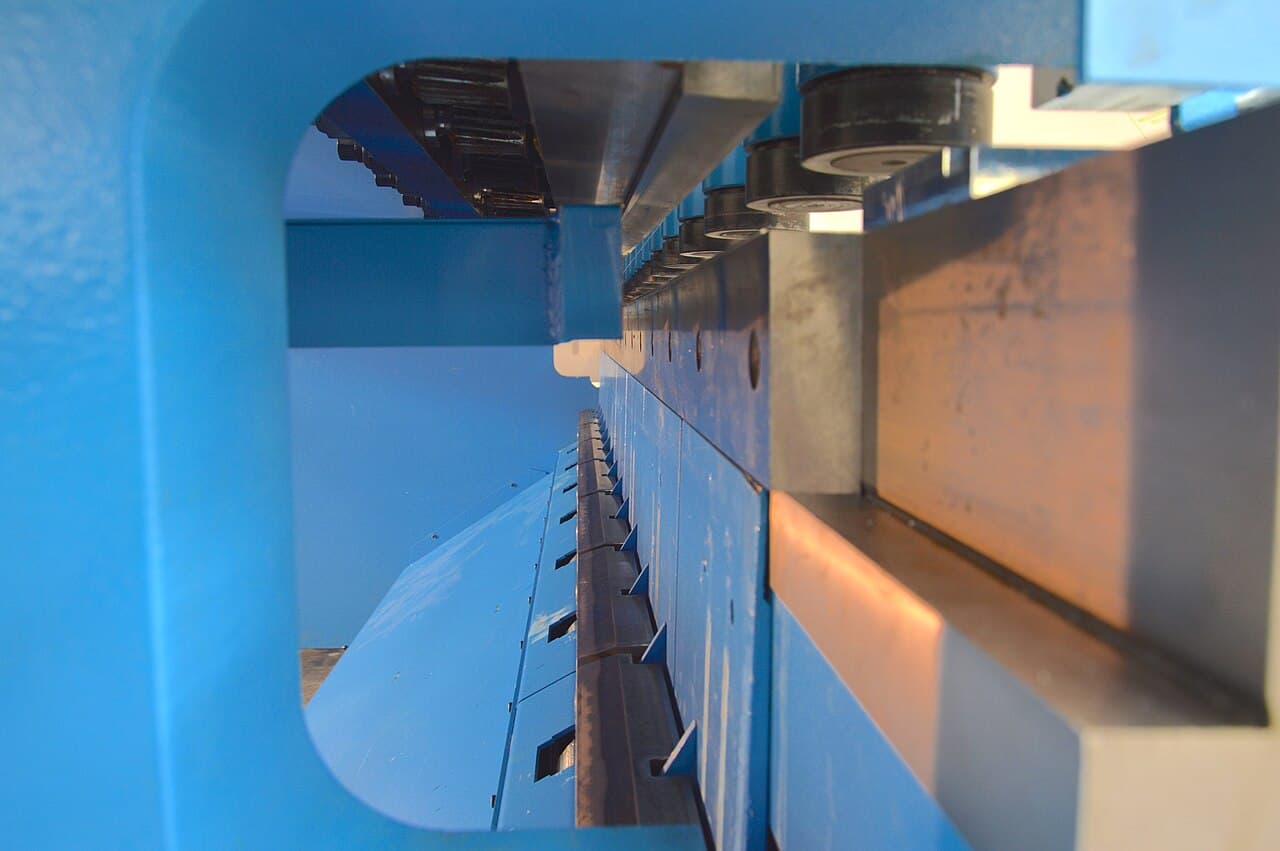 Blade and clamping components inside a blue sheet-metal shear